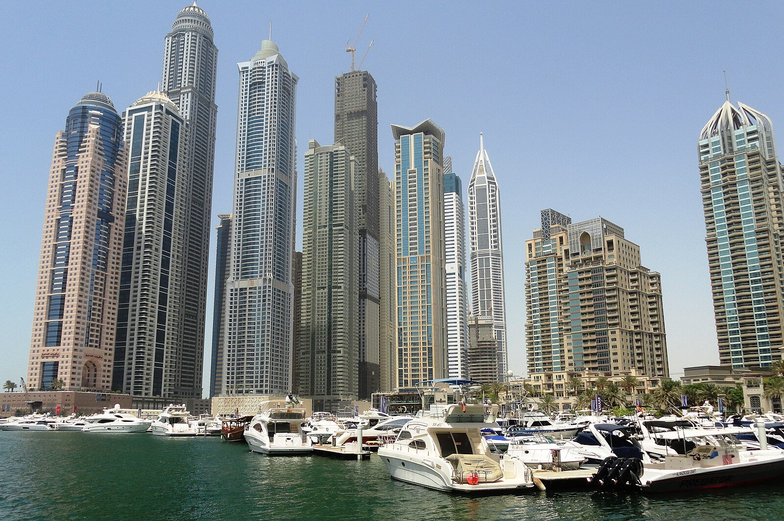 Residential towers, including 23 Marina, rise above rows of moored motor yachts in Dubai Marina.