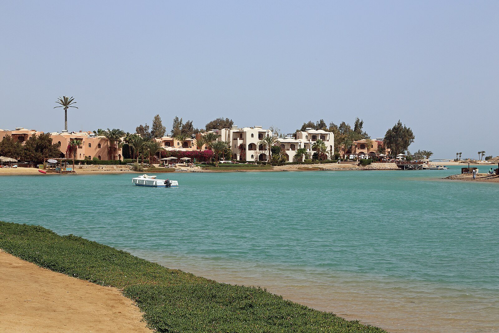 Ochre and white villas among palms along a turquoise lagoon in El Gouna on the Red Sea.