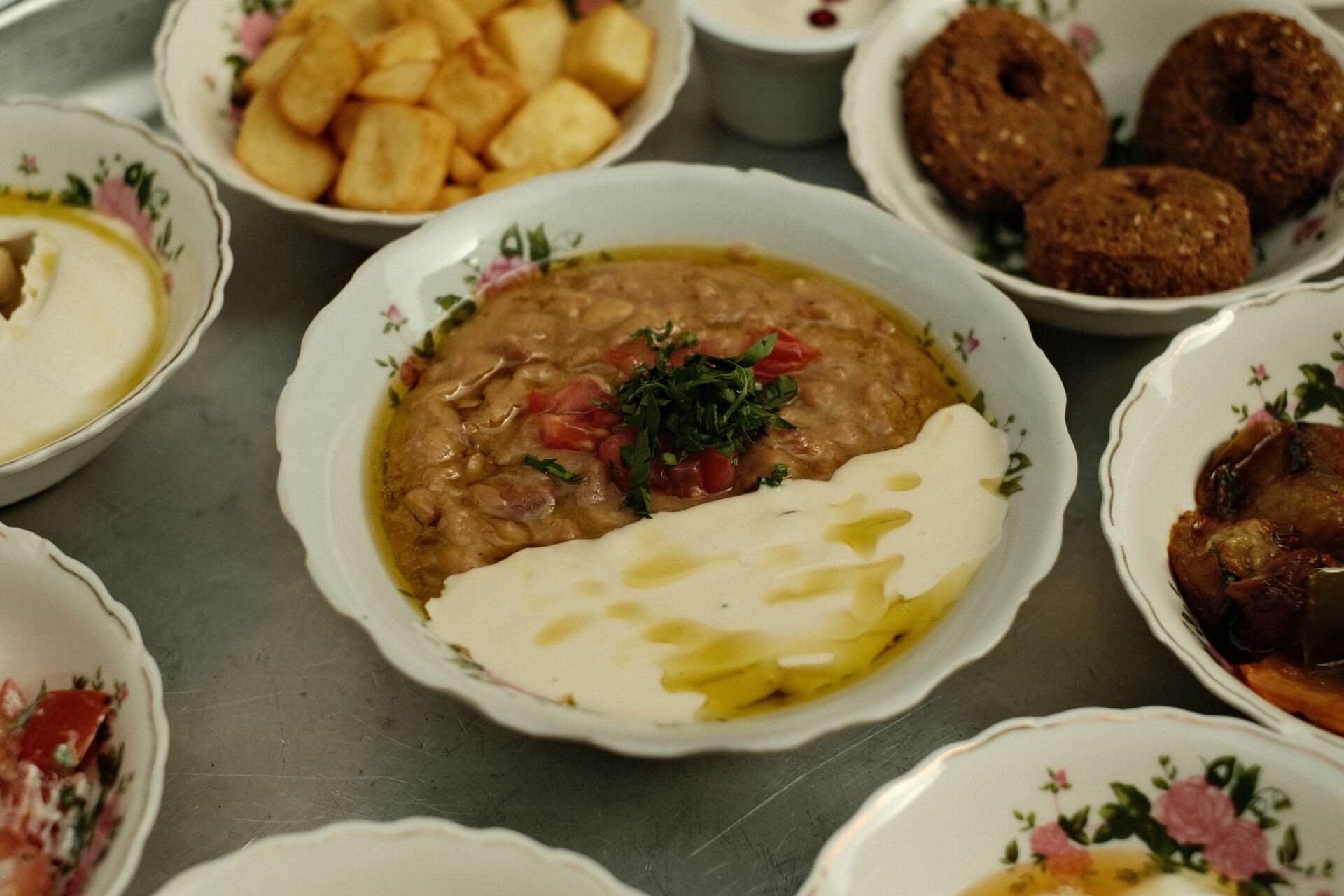 A spread of Arabic dishes: ful medames with tahini, falafel and hummus