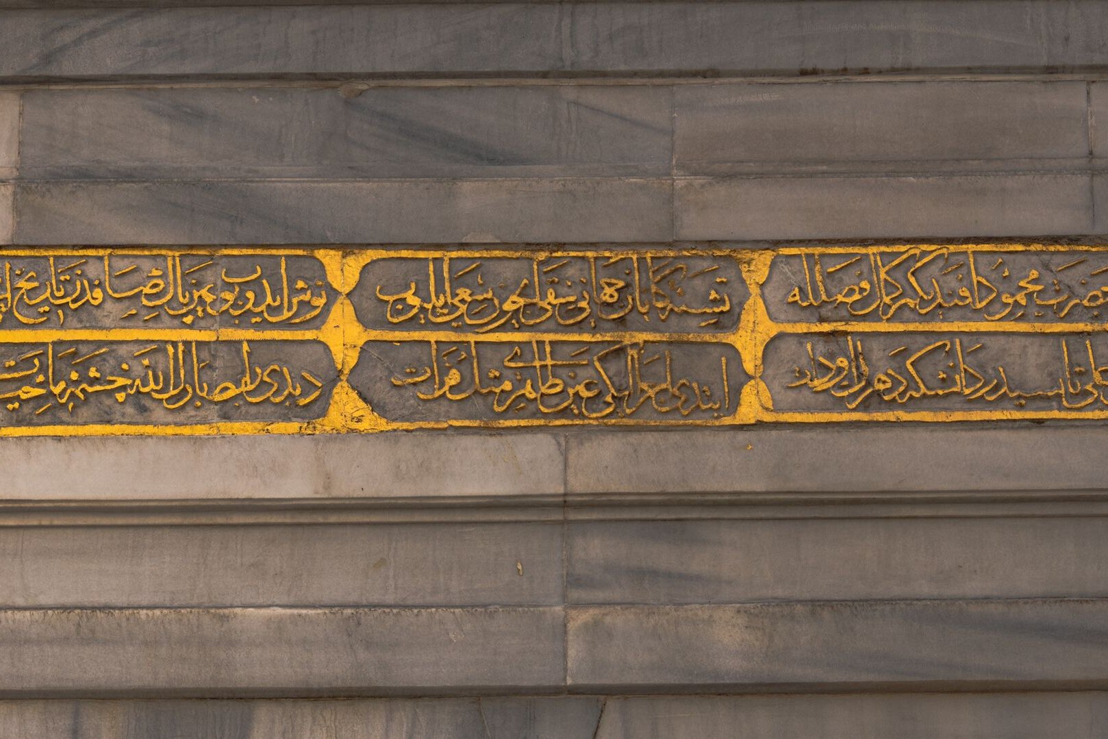 Gilded calligraphy carved into a marble wall