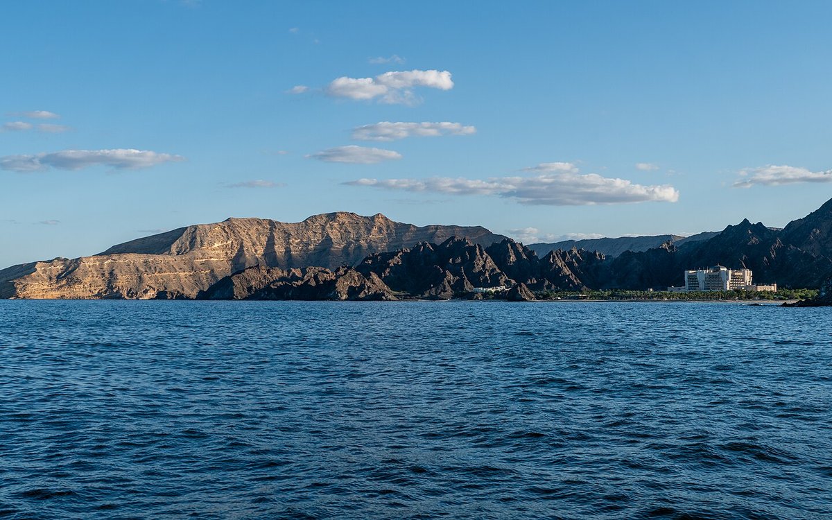 Al Bustan Palace on its private bay beneath the Hajar Mountains, seen from the Gulf of Oman near Muscat