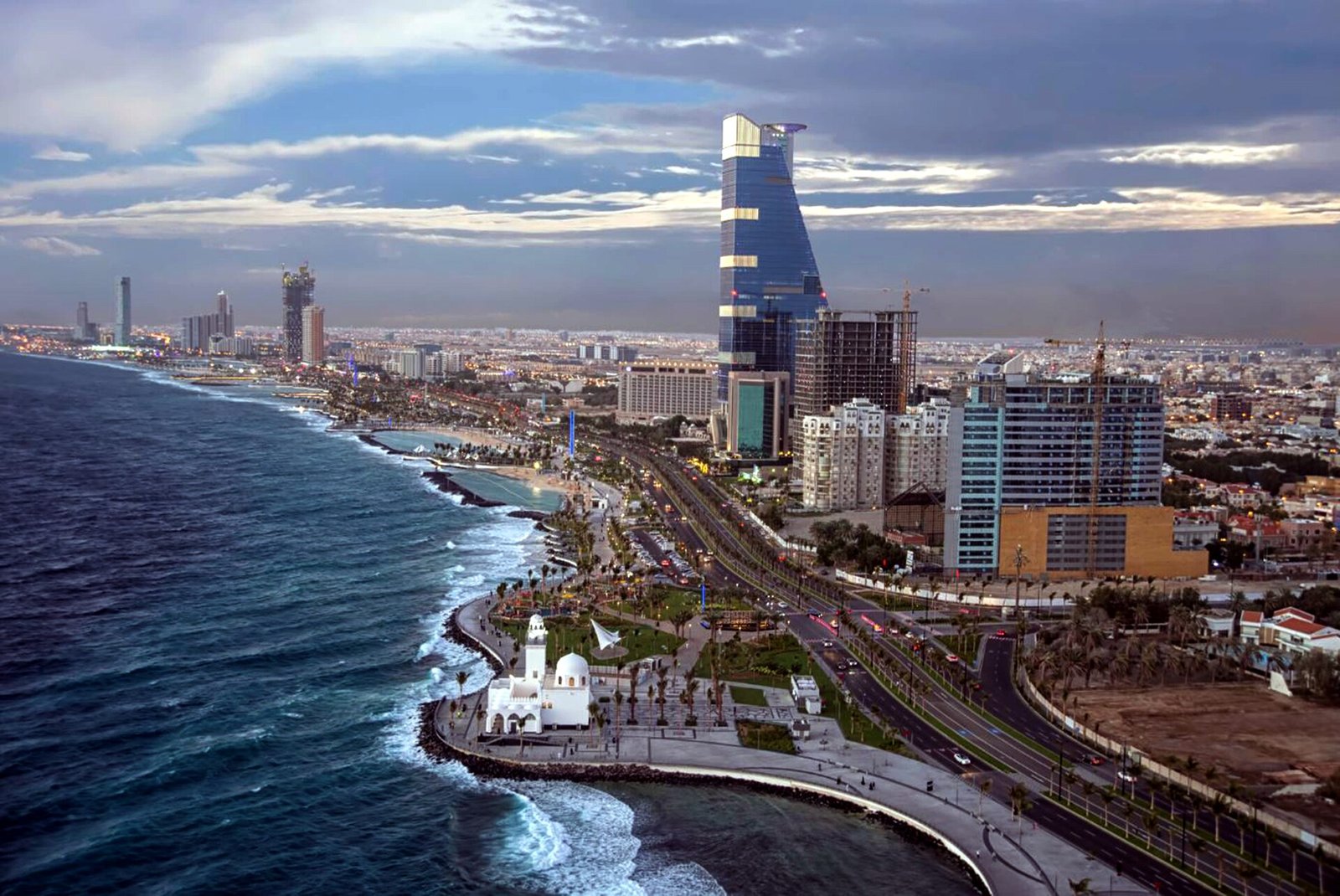 The Jeddah Corniche curves along the Red Sea past the floating mosque and the towers of the city.
