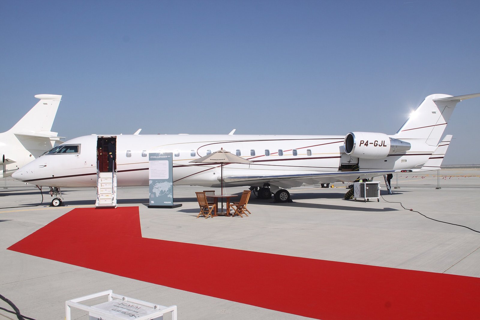 A private jet waiting on a red carpet at Dubai's Al Maktoum International Airport.