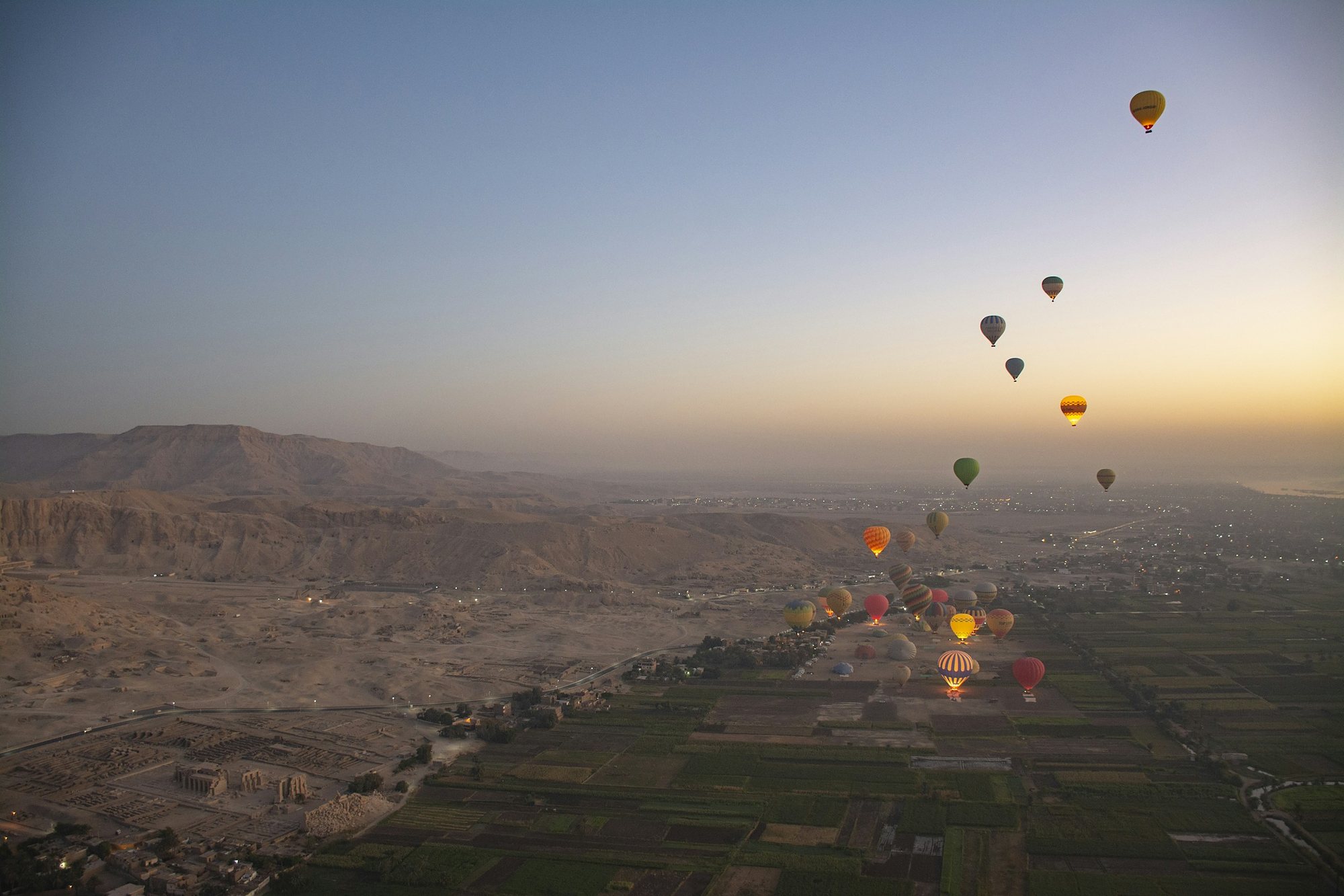 Hot-air balloons rising over the West Bank of Luxor at sunrise