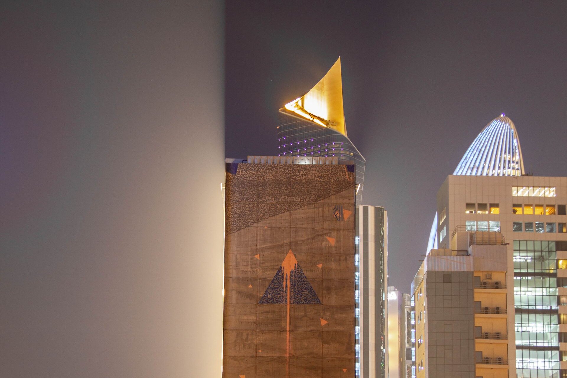 The sail-shaped crown of Al Hamra Tower lit at night, Kuwait City