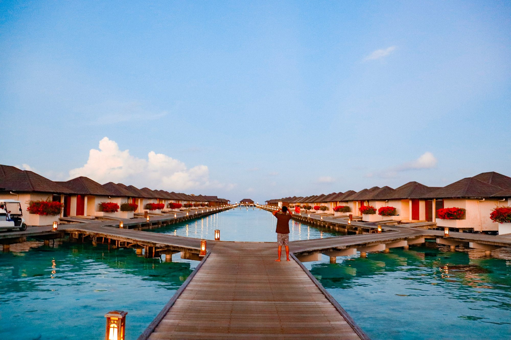 A boardwalk between overwater villas at dusk