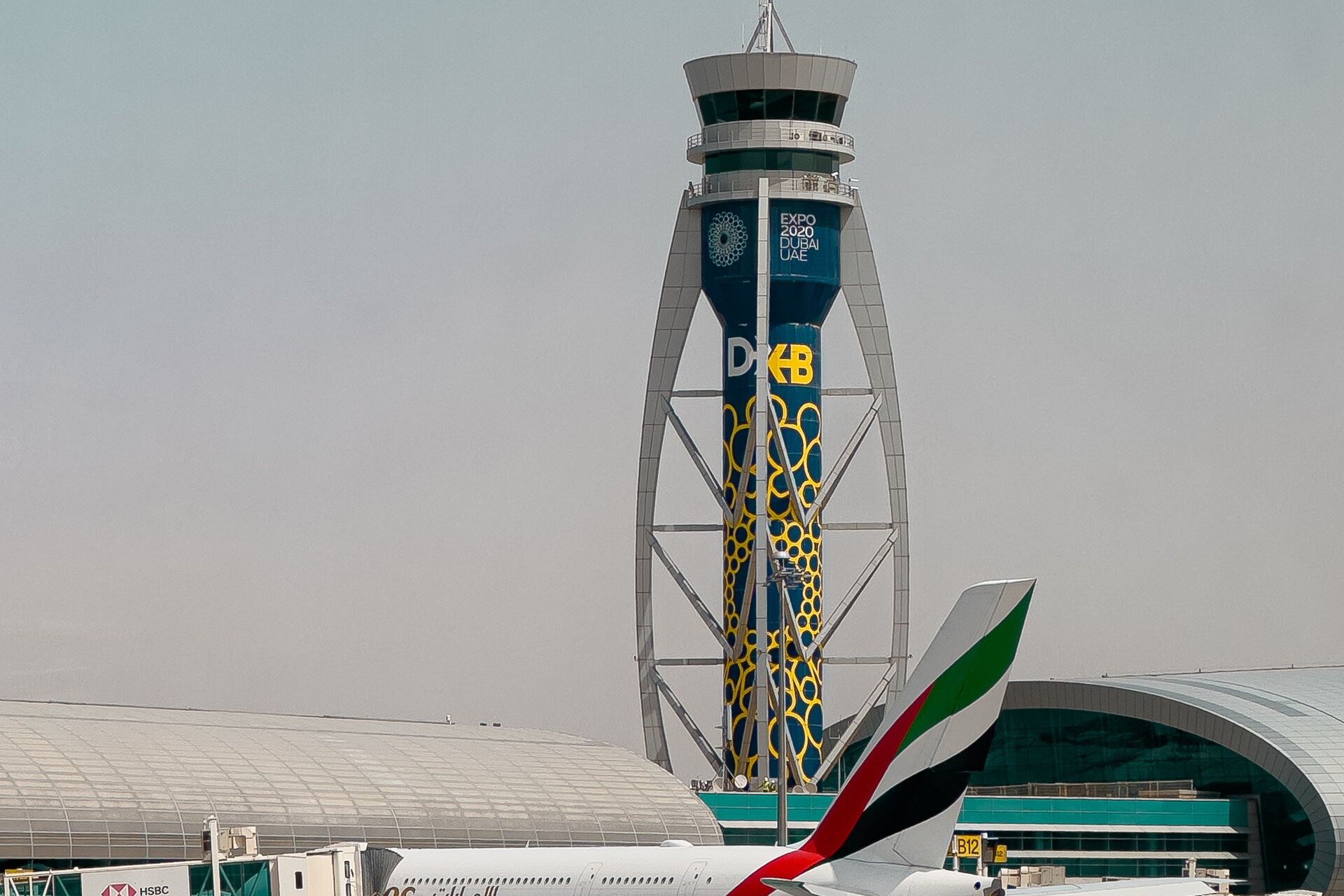 An Emirates A380 at the gate below the control tower, Dubai International Airport