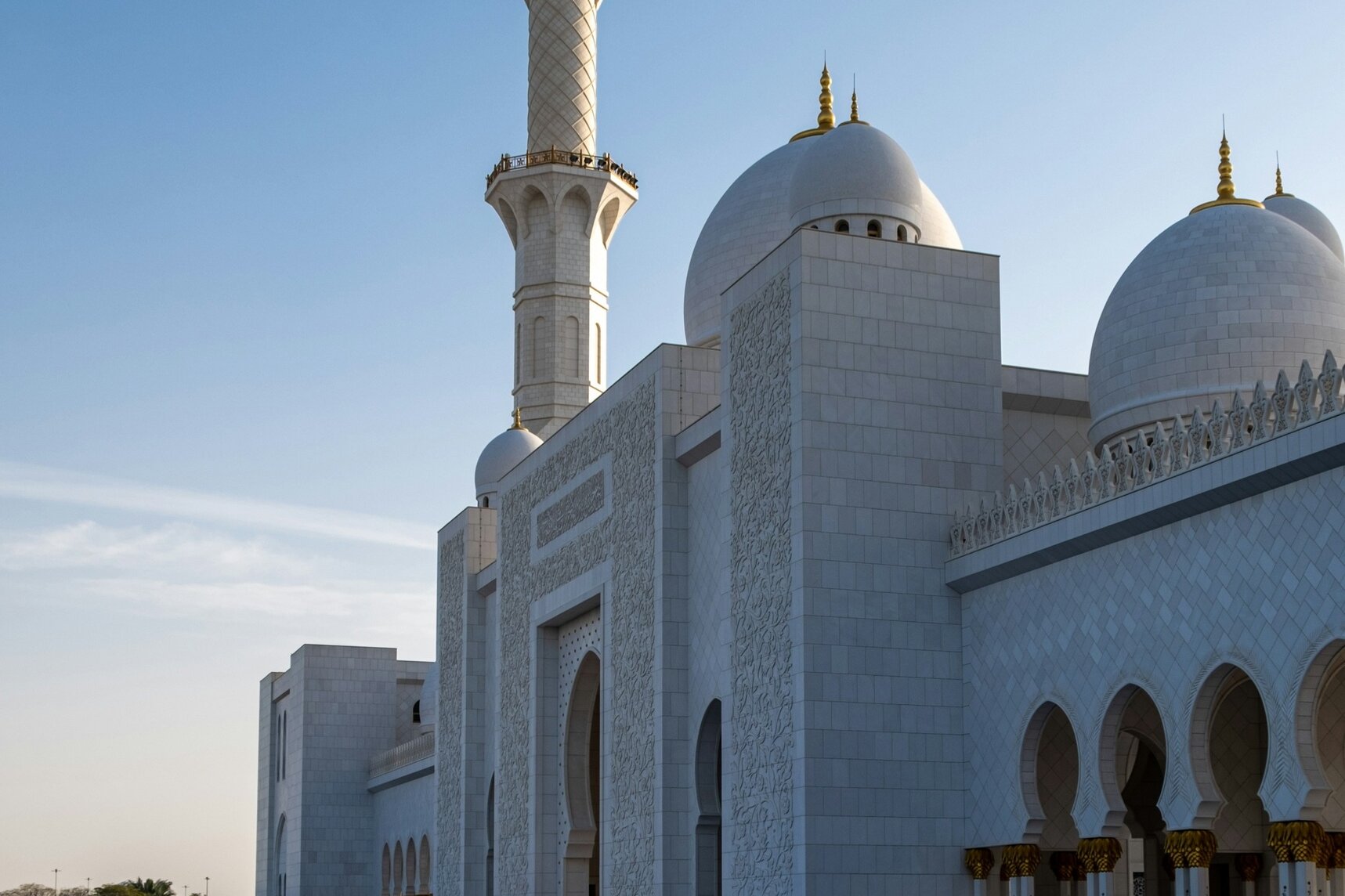 A minaret and domes of the Sheikh Zayed Grand Mosque above its reflecting pool, Abu Dhabi