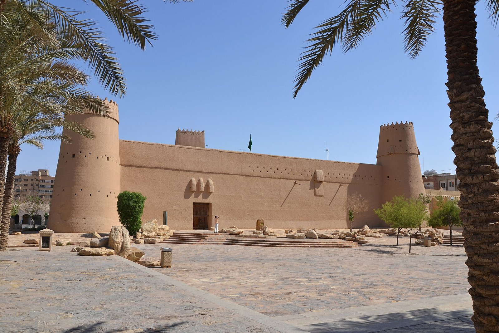 The mud-brick towers and walls of Masmak Fortress in central Riyadh, framed by palms under a blue sky