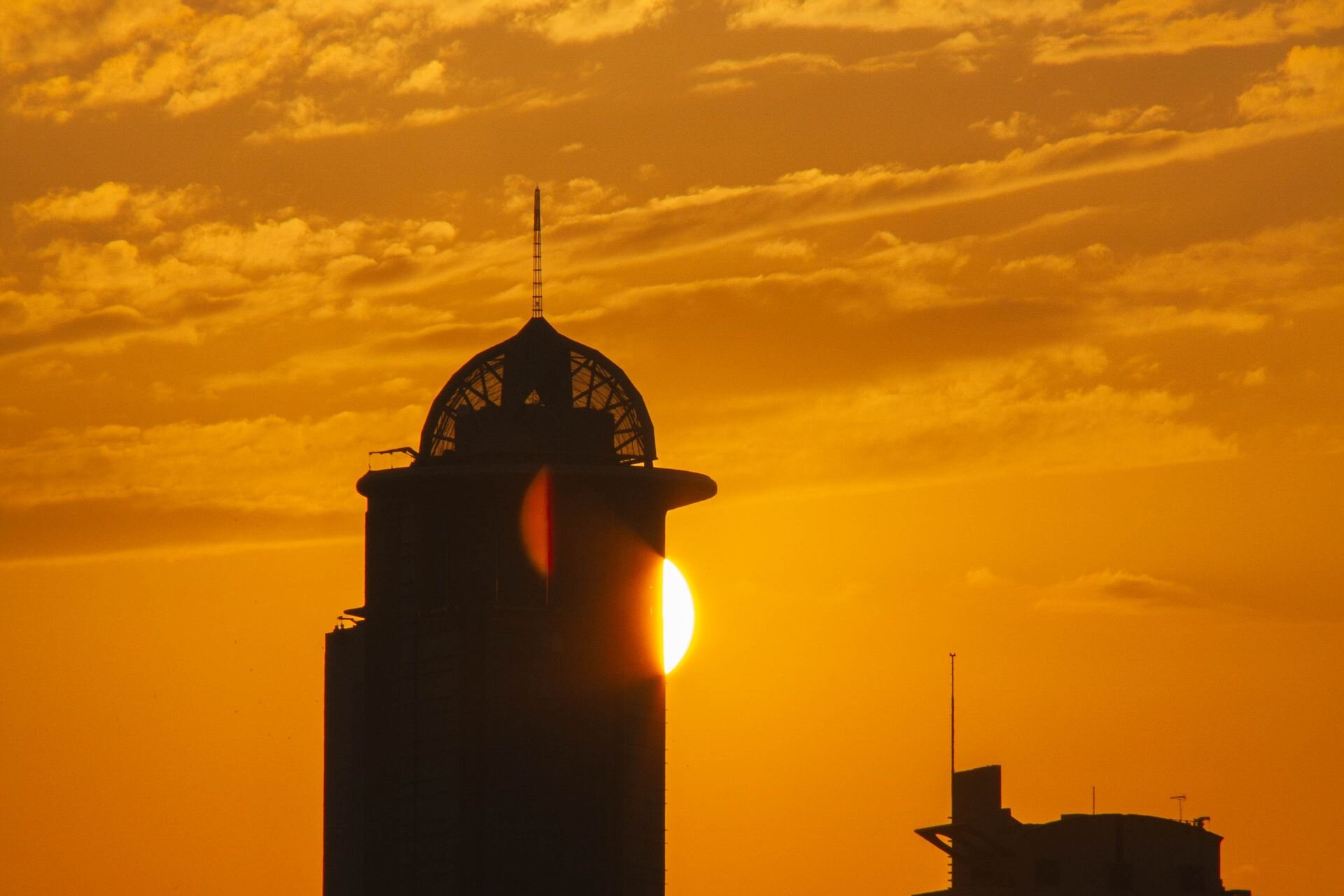 Kuwait City towers silhouetted against a golden sunset