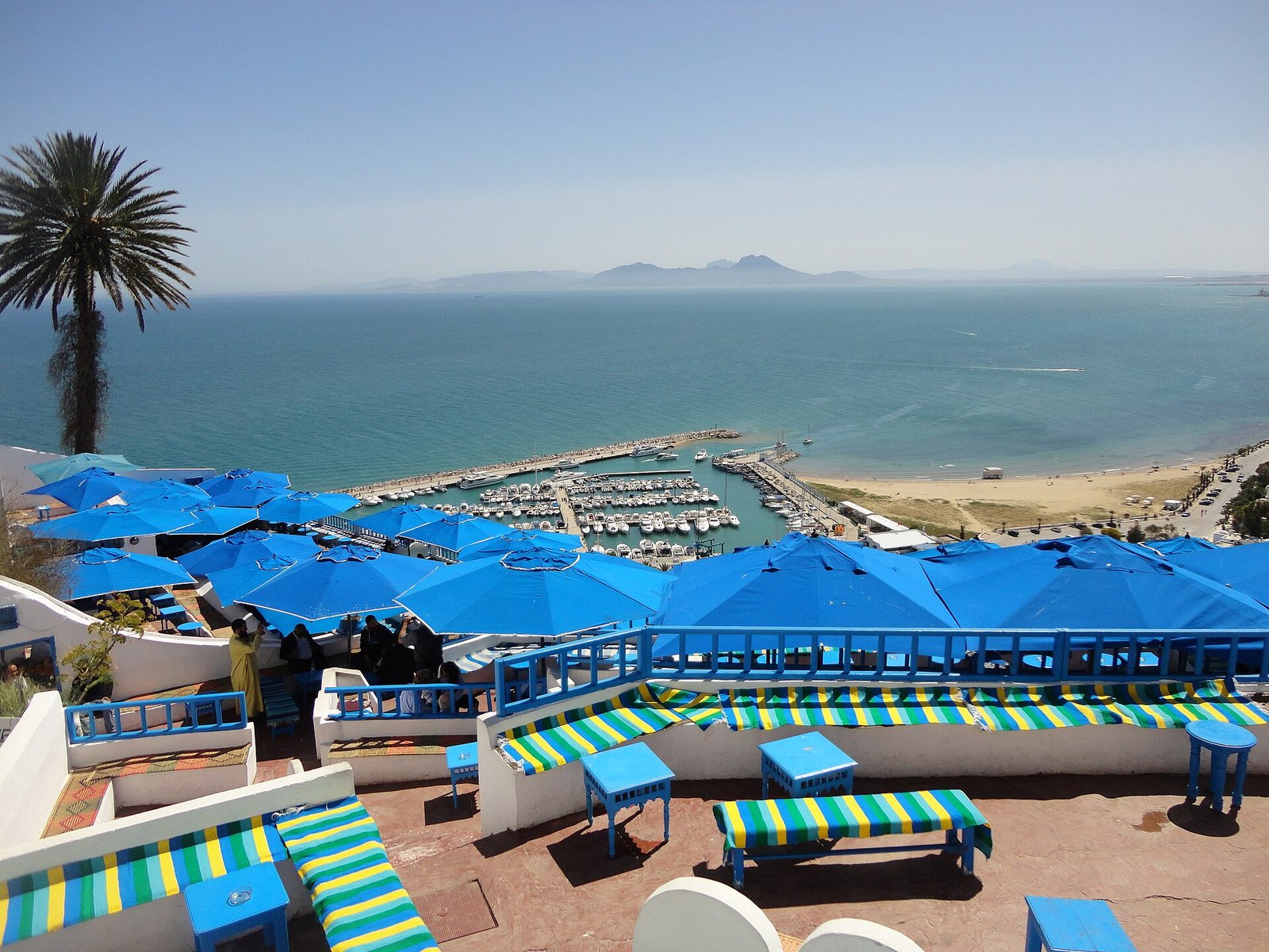 Blue parasols on the terraces of the Café des Délices in Sidi Bou Said, above the marina and the Gulf of Tunis
