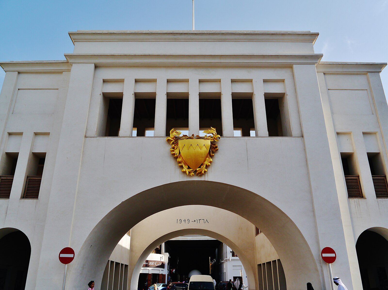 The white arched gateway of Bab Al Bahrain, crowned with the national emblem, at the entrance to the Manama souq.