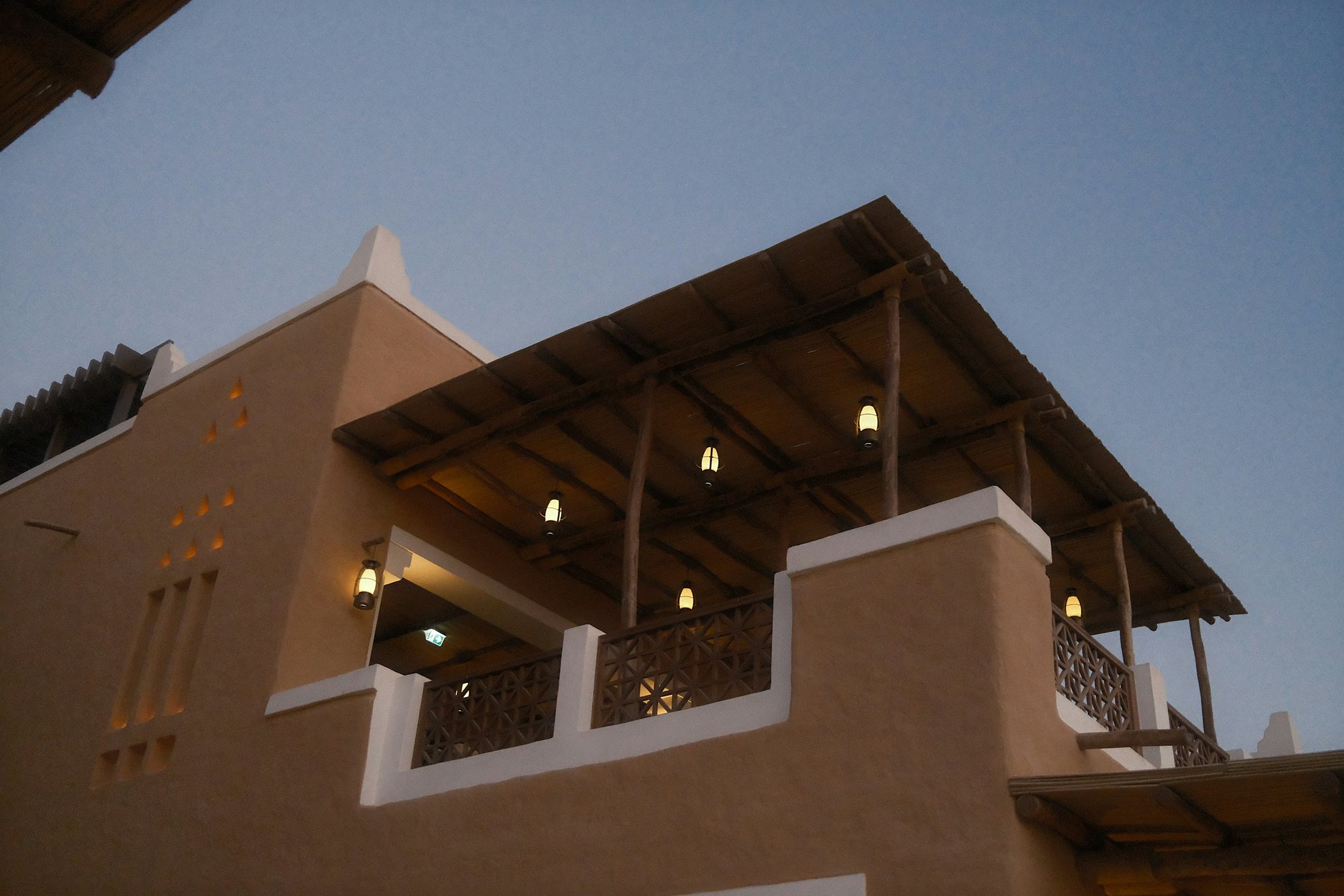 Lanterns glowing on a mud-brick terrace in Diriyah at dusk