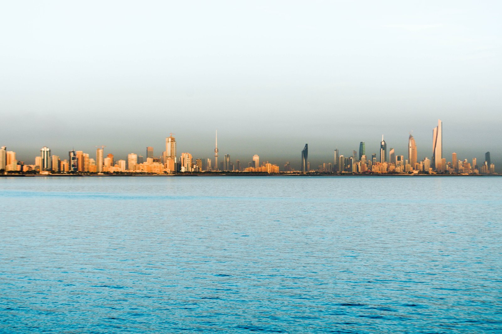 The Kuwait City skyline catching the early light across the calm waters of the Gulf.