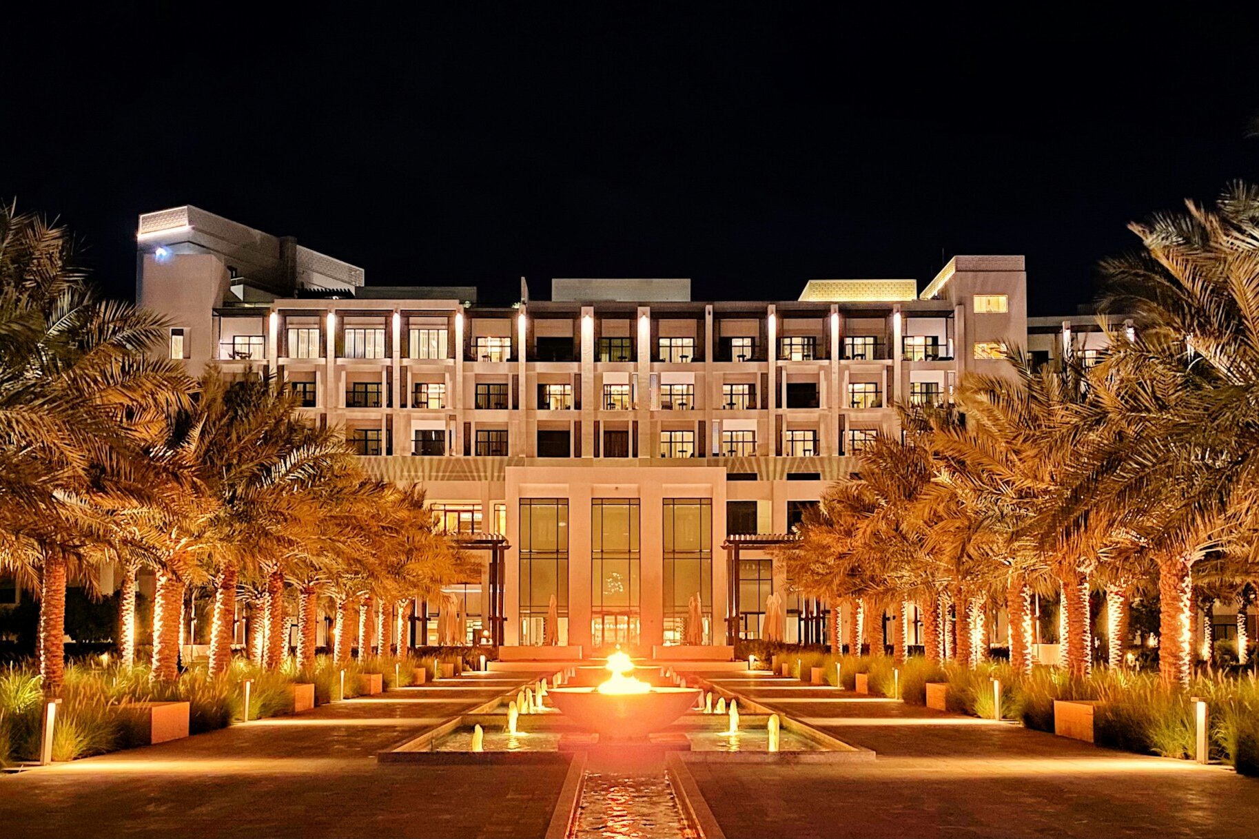 A palm-lined beach resort lit at night on the Fujairah coast