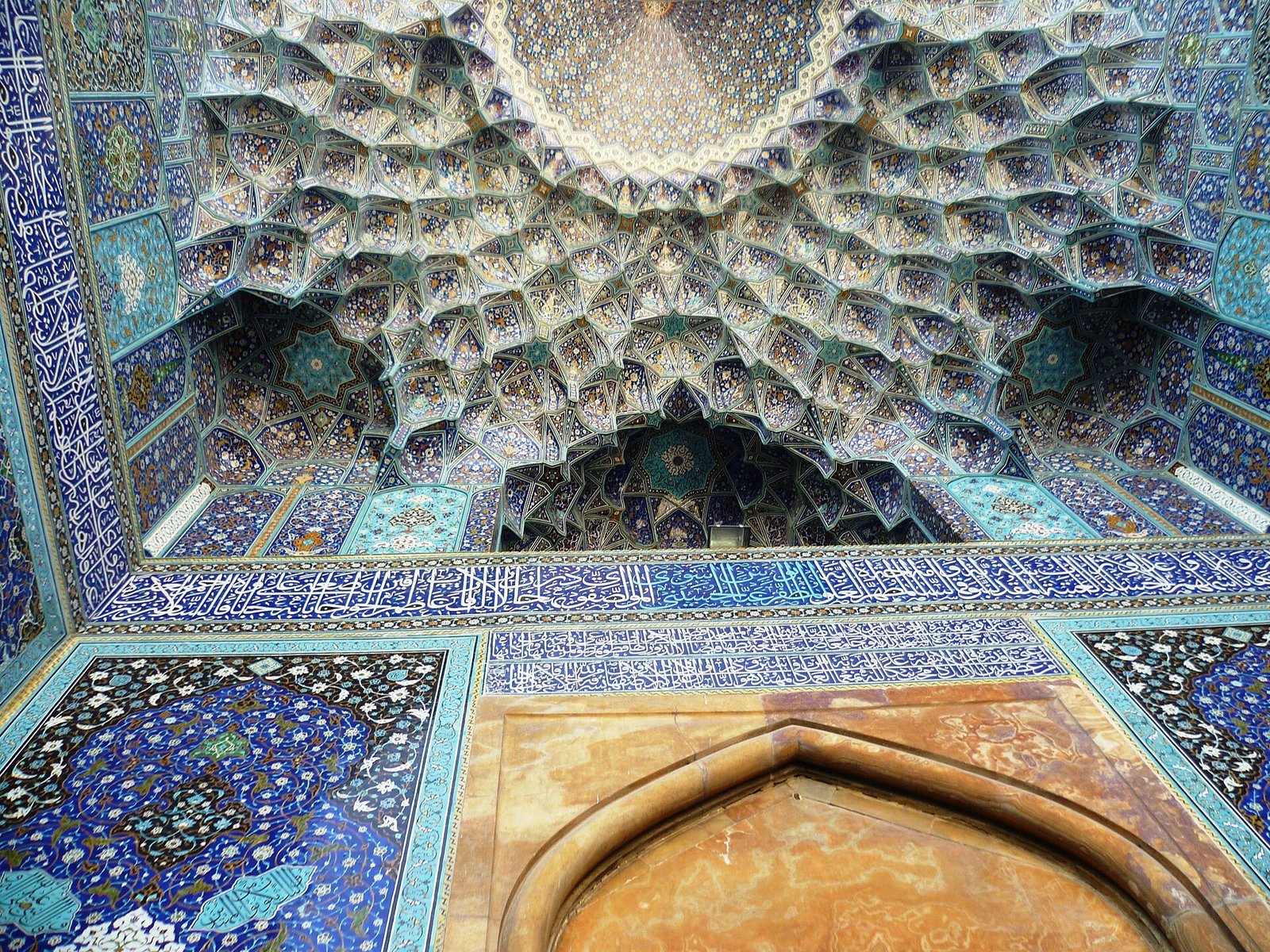 The honeycomb muqarnas vault of the entrance iwan of the Shah Mosque in Isfahan, sheathed in blue tilework.