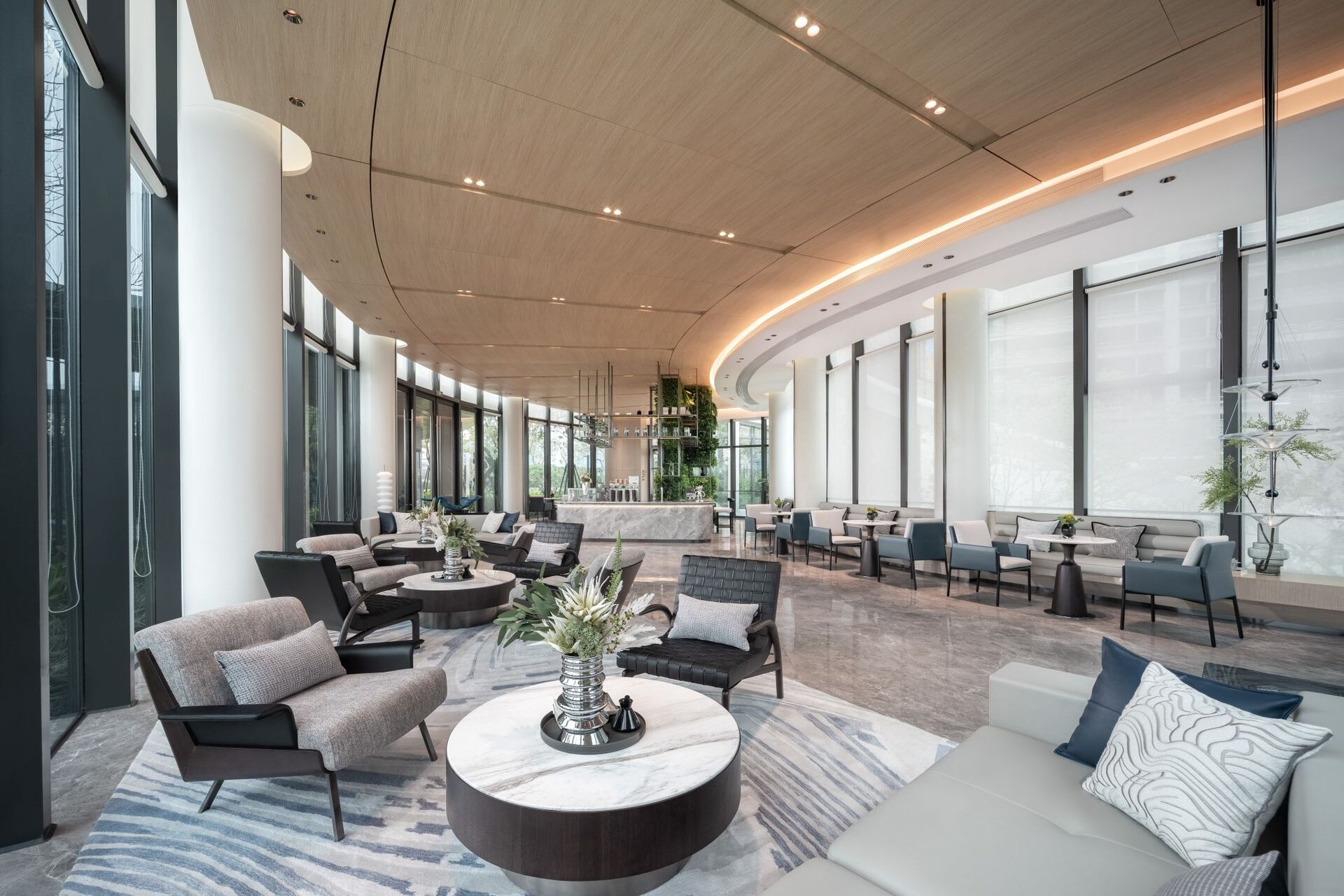 A quiet, light-filled private lounge with marble tables and deep armchairs
