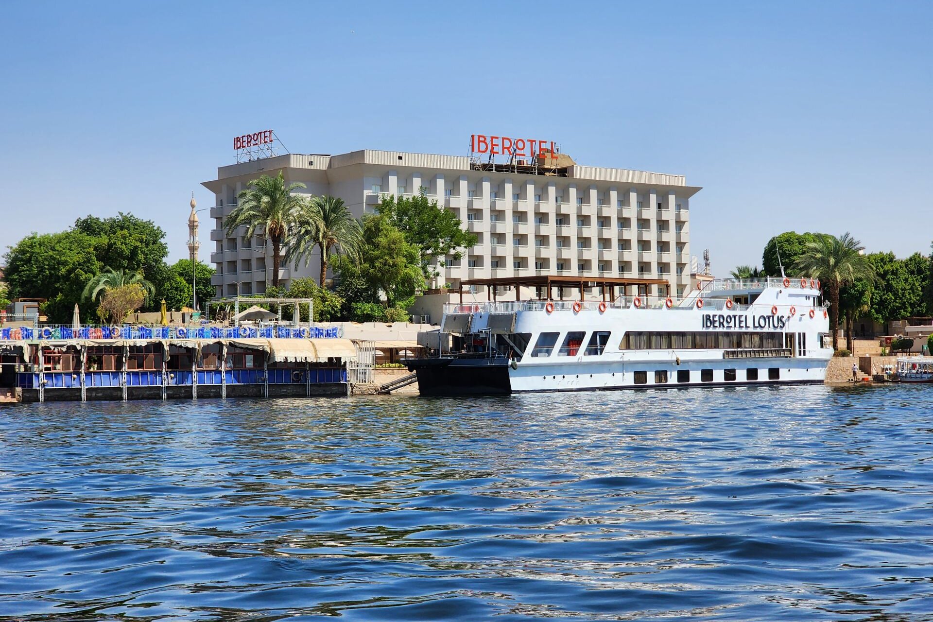 A Nile cruise boat moored below a riverside hotel in Luxor, Egypt