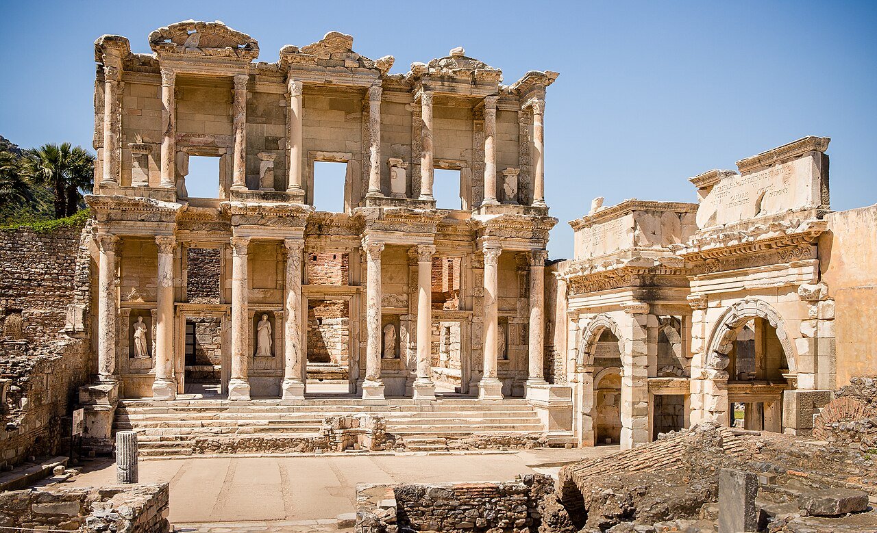 The two-storey marble facade of the Library of Celsus at Ephesus under a clear sky.