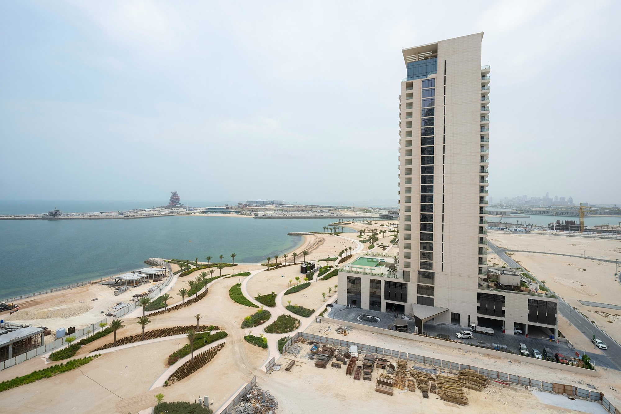 A new tower and seafront park on the Lusail coast, with Qetaifan Island beyond