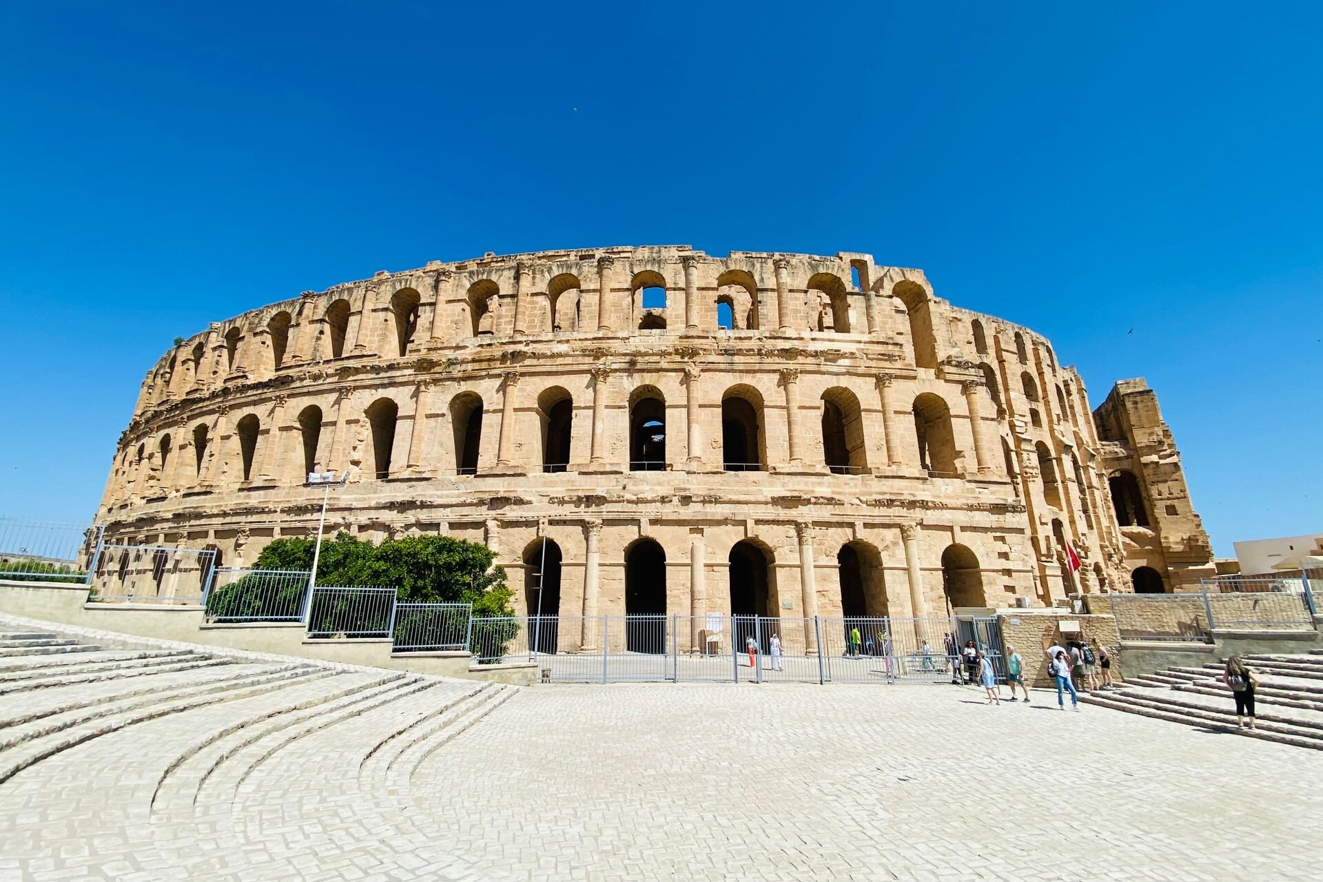 The Roman amphitheatre of El Jem, Tunisia, under a deep blue sky
