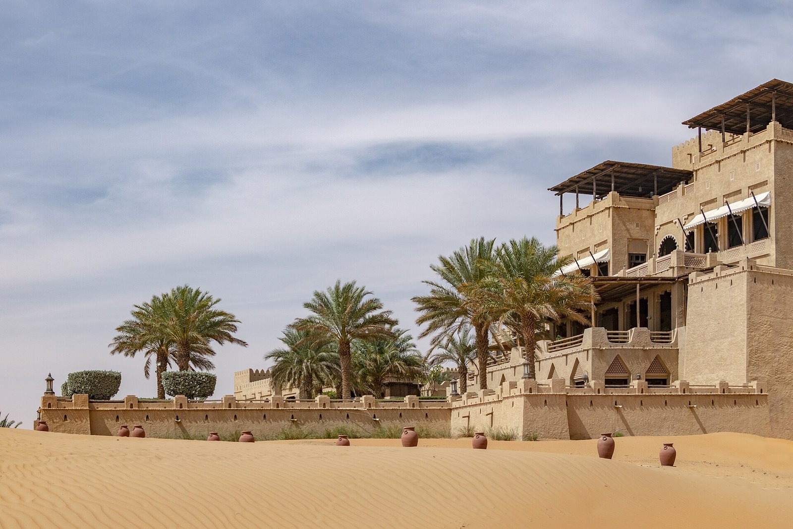 The palm-fringed desert palace architecture of Qasr Al Sarab resort rising from the dunes of the Empty Quarter, Abu Dhabi.