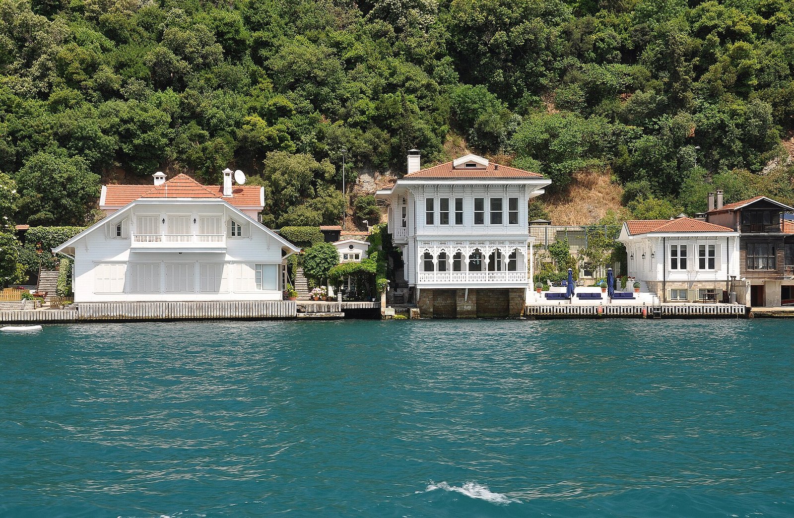 Elegant white and red-roofed yali mansions lining the wooded Bosphorus shore at Kanlica, Istanbul.