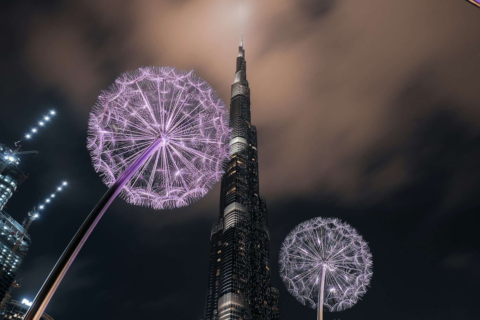 Lit dandelion sculptures beneath the Burj Khalifa at night
