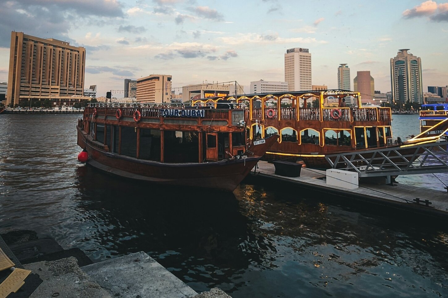 Traditional dhows moored on Dubai Creek beneath the towers of Deira