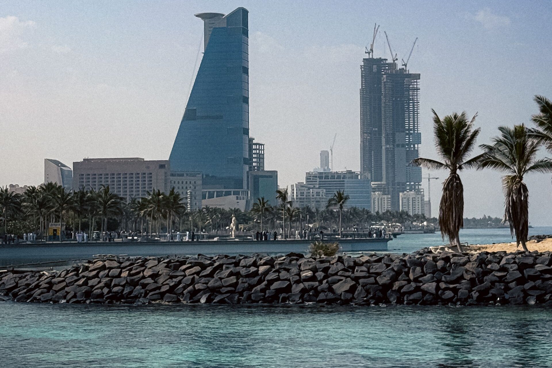 Towers rising beyond the palms and breakwater of the Jeddah Corniche on the Red Sea