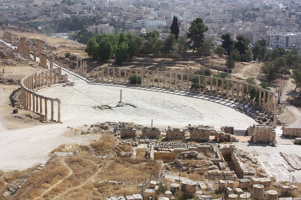 The colonnaded Oval Plaza of Roman Jerash seen from above, with the modern town beyond.