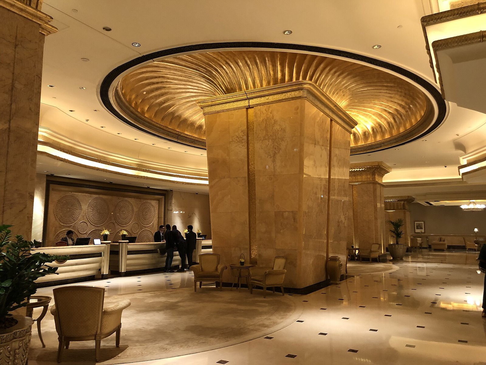 A gilded domed ceiling above a marble column in the lobby of Emirates Palace, Abu Dhabi.