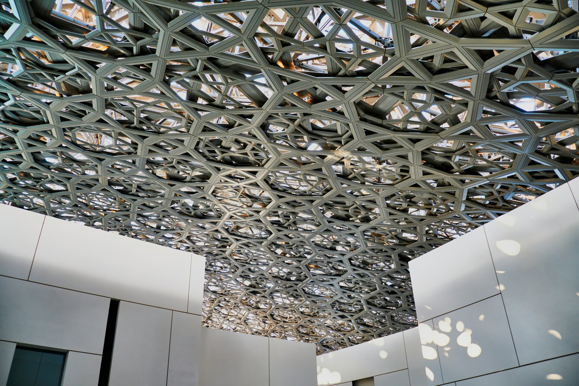 The lattice dome of the Louvre Abu Dhabi, filtering a rain of light