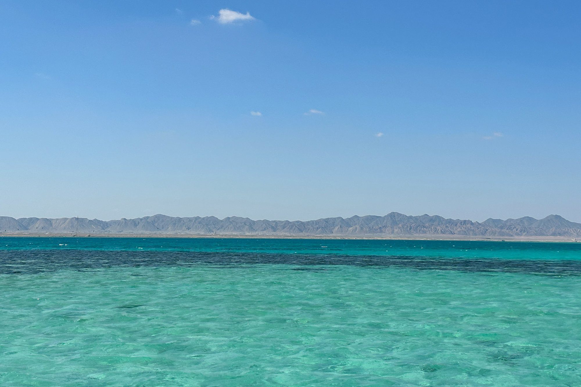 Aguas turquesas poco profundas del Mar Rojo bajo las montañas cerca de El Gouna