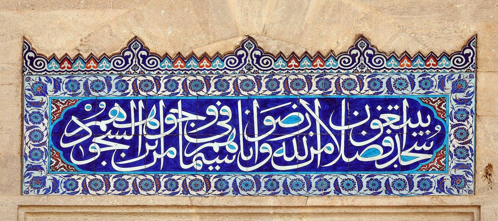 Una franja de caligrafía árabe blanca sobre azulejos de Iznik color cobalto en el patio de la Mezquita de Süleymaniye, Estambul.