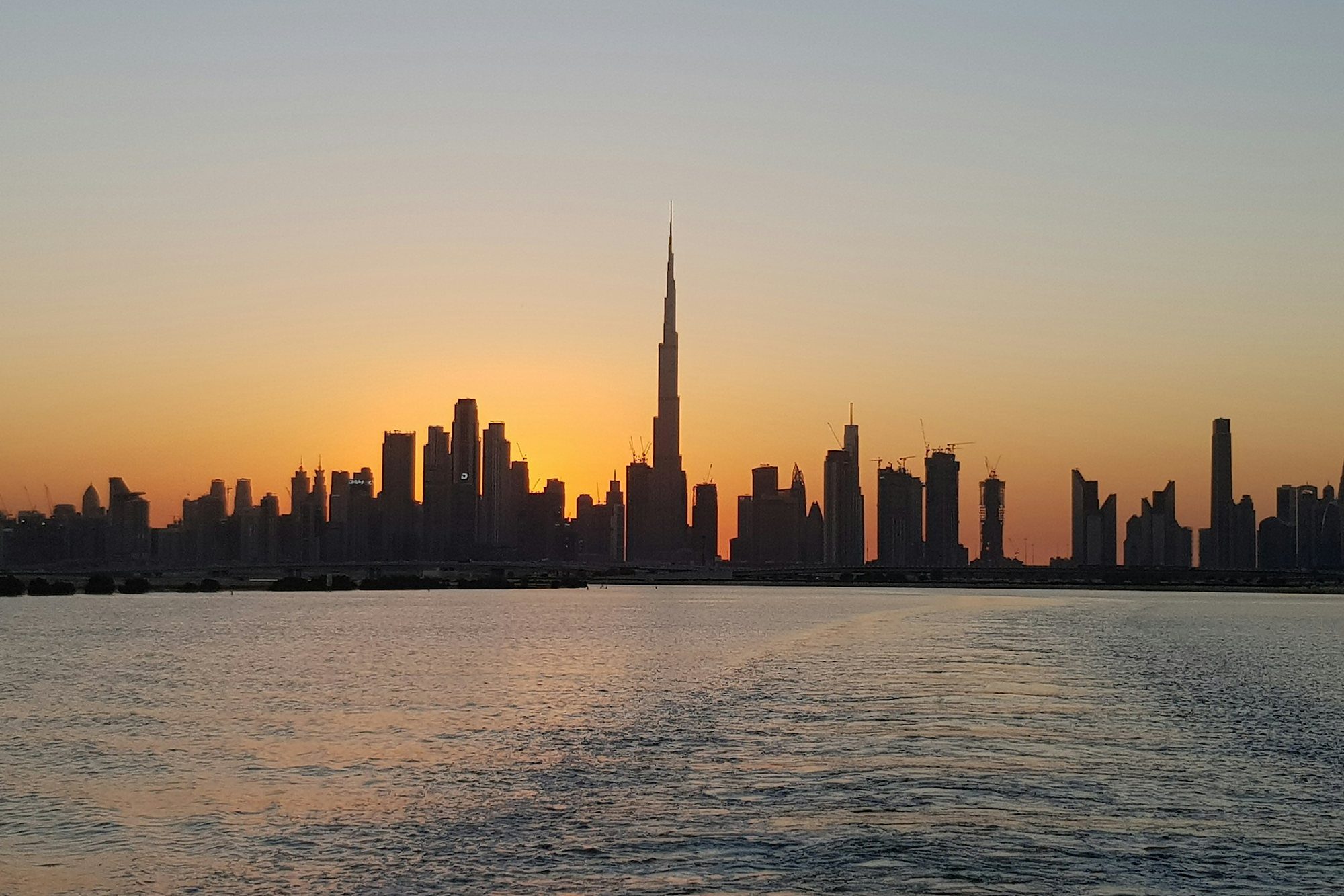 El perfil urbano de Dubái al atardecer desde Dubai Creek Harbour