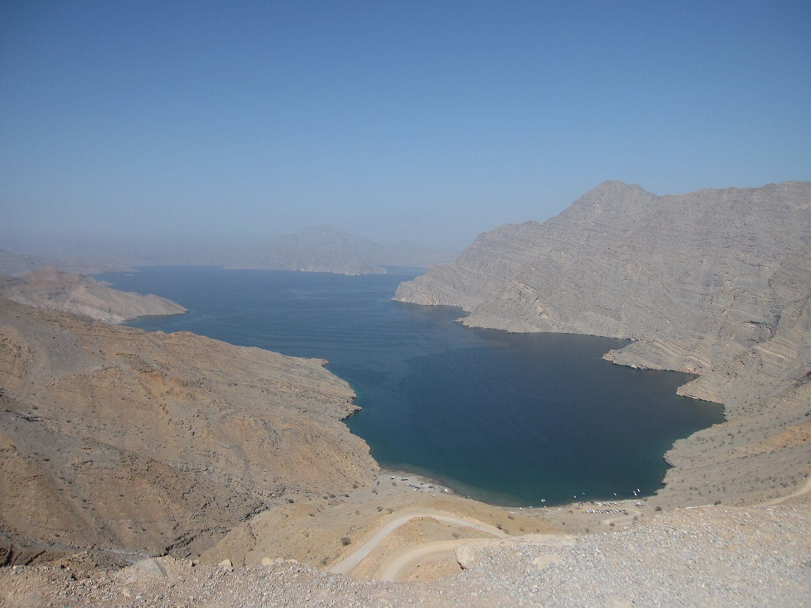 Un fiordo de azul profundo entre montañas desnudas en la península de Musandam, Omán