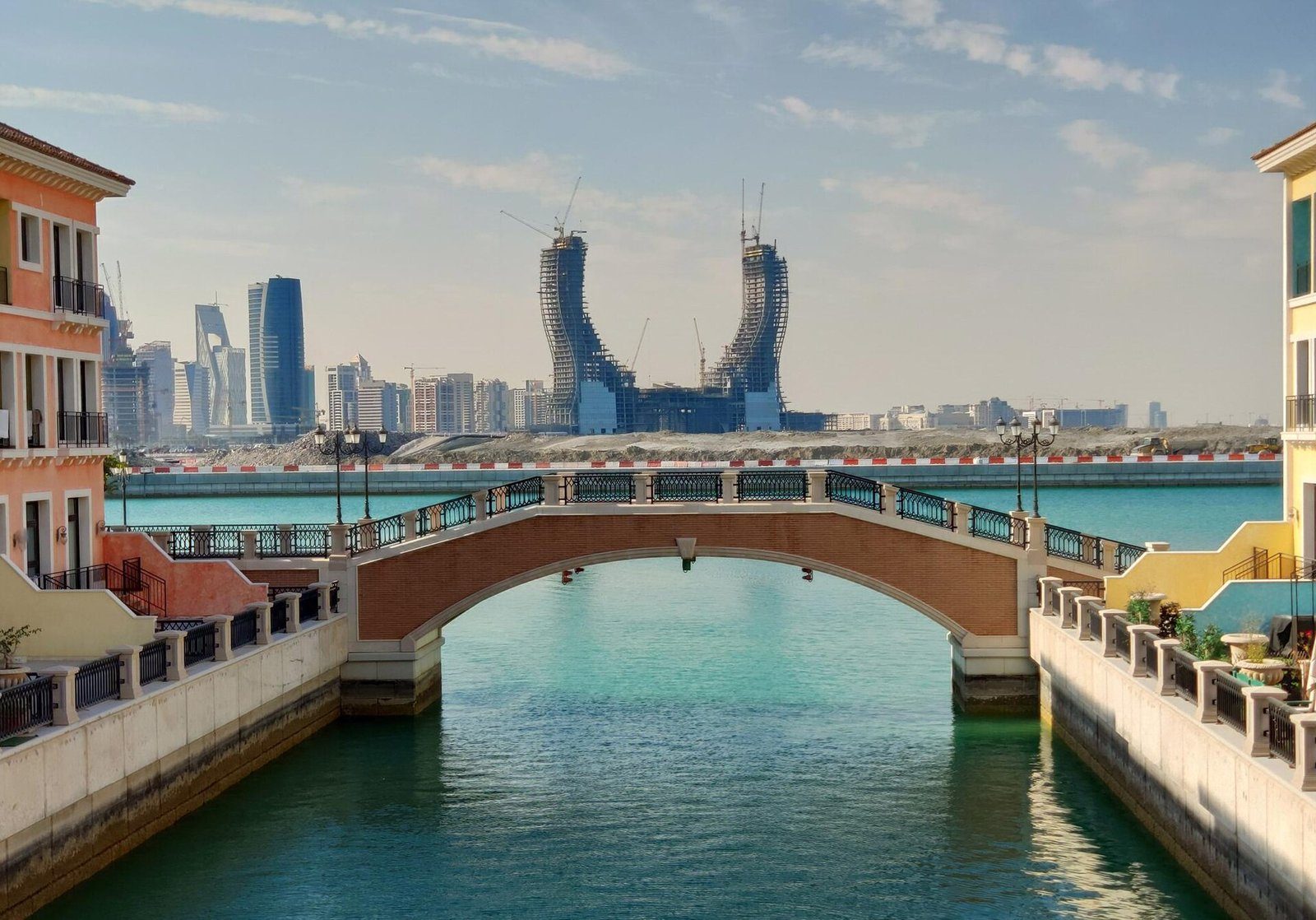 Un puente de estilo veneciano sobre un canal en la isla de Qetaifan, en Lusail, con las Katara Towers en forma de media luna al fondo.