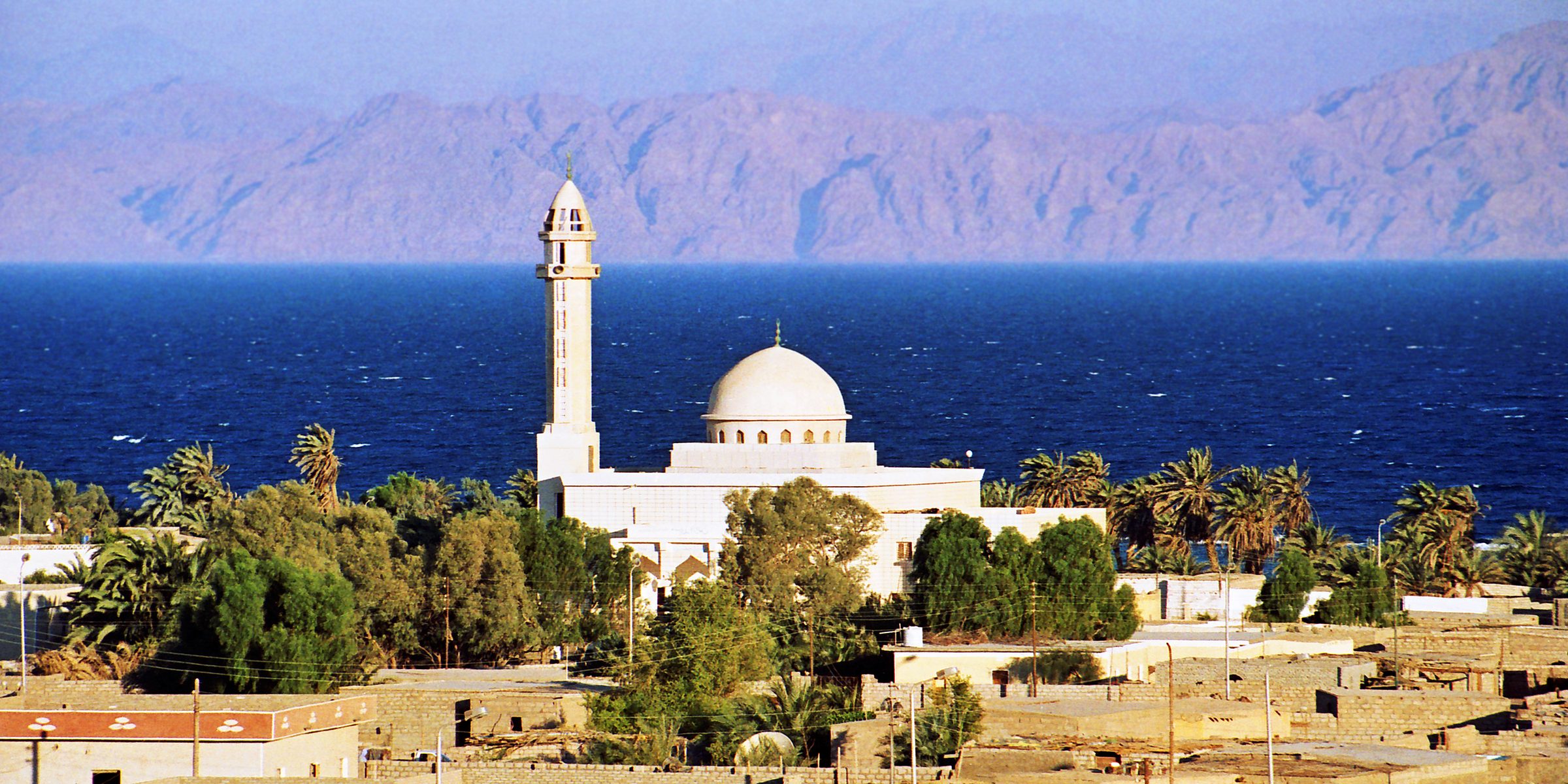 Una mezquita blanca a orillas del golfo de Áqaba, con las montañas de Arabia al fondo, Dahab
