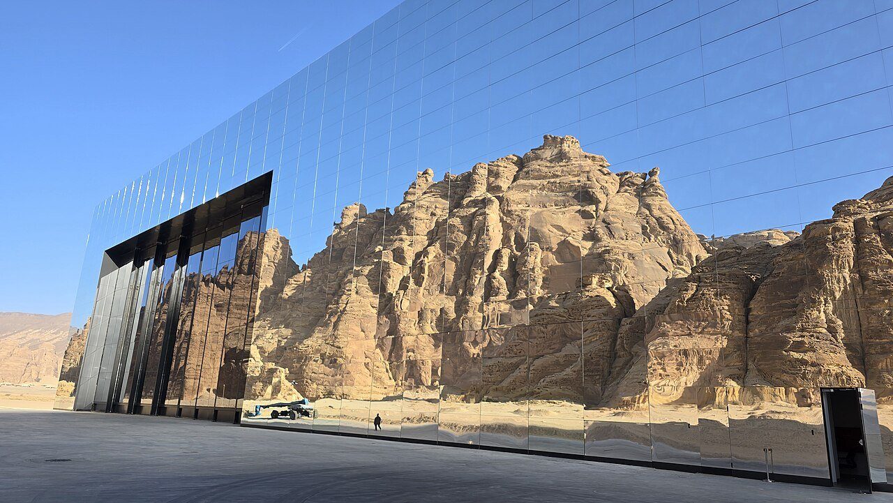Los acantilados de arenisca de AlUla reflejados en la fachada de espejos de Maraya, la sala de conciertos del desierto.