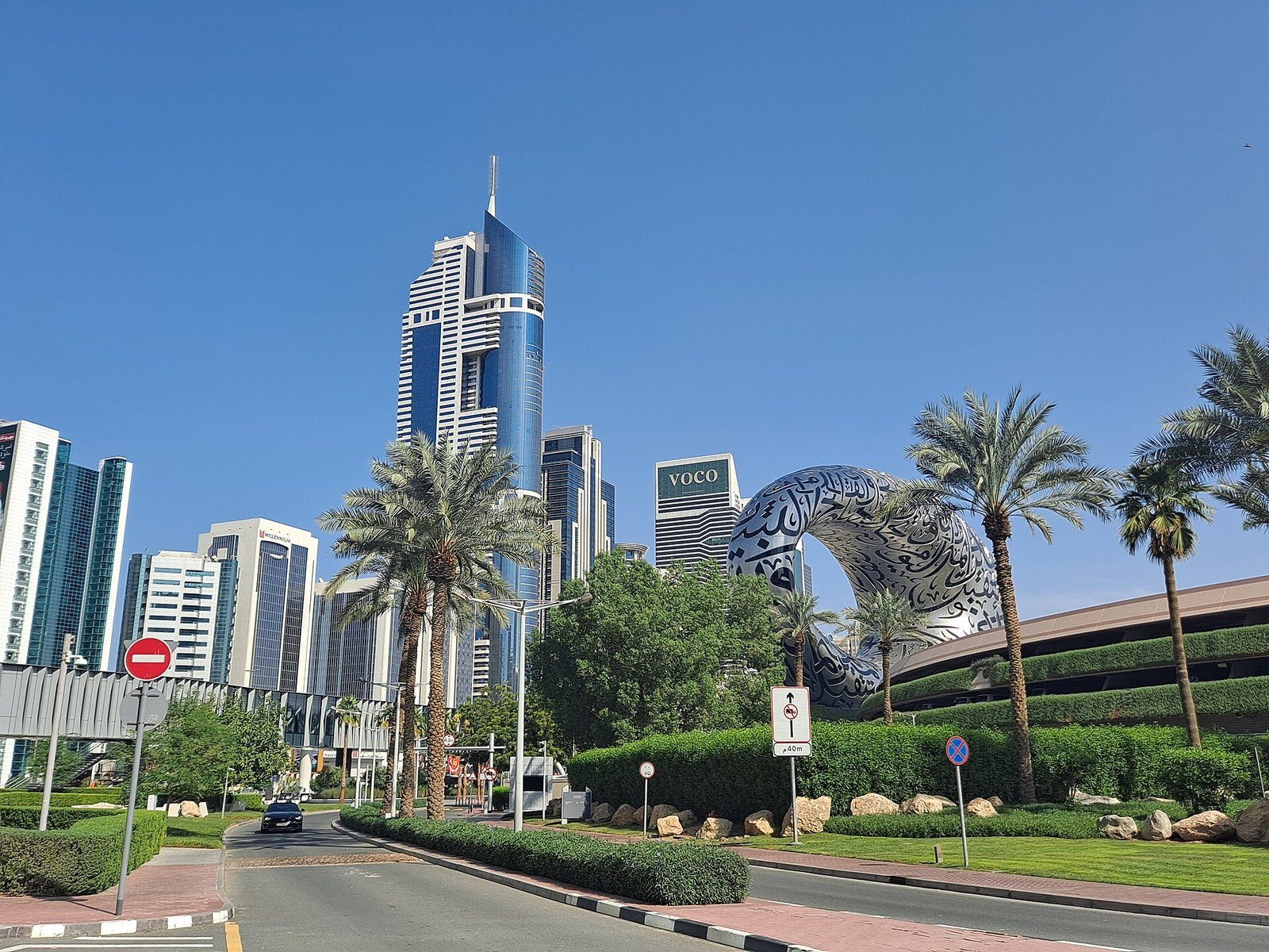 El anillo plateado y revestido de caligrafía del Museo del Futuro entre palmeras y torres en la Sheikh Zayed Road, Dubái