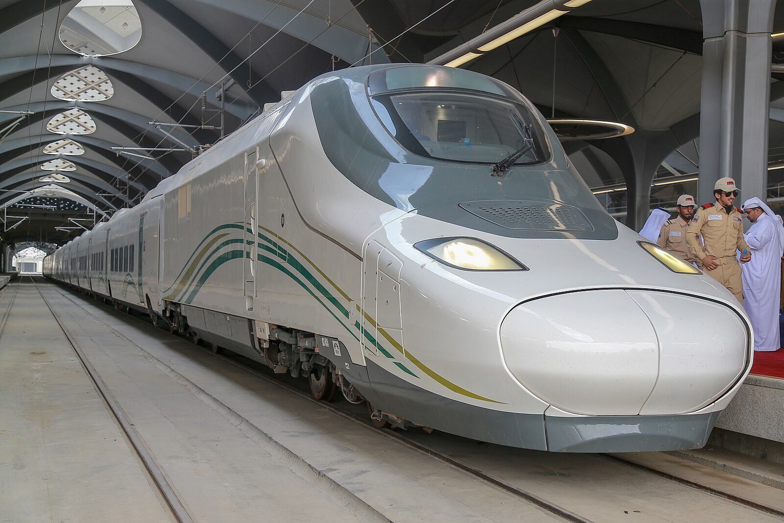 Un elegante tren blanco del Haramain High Speed Railway esperando en el andén bajo la cubierta abovedada de la estación.