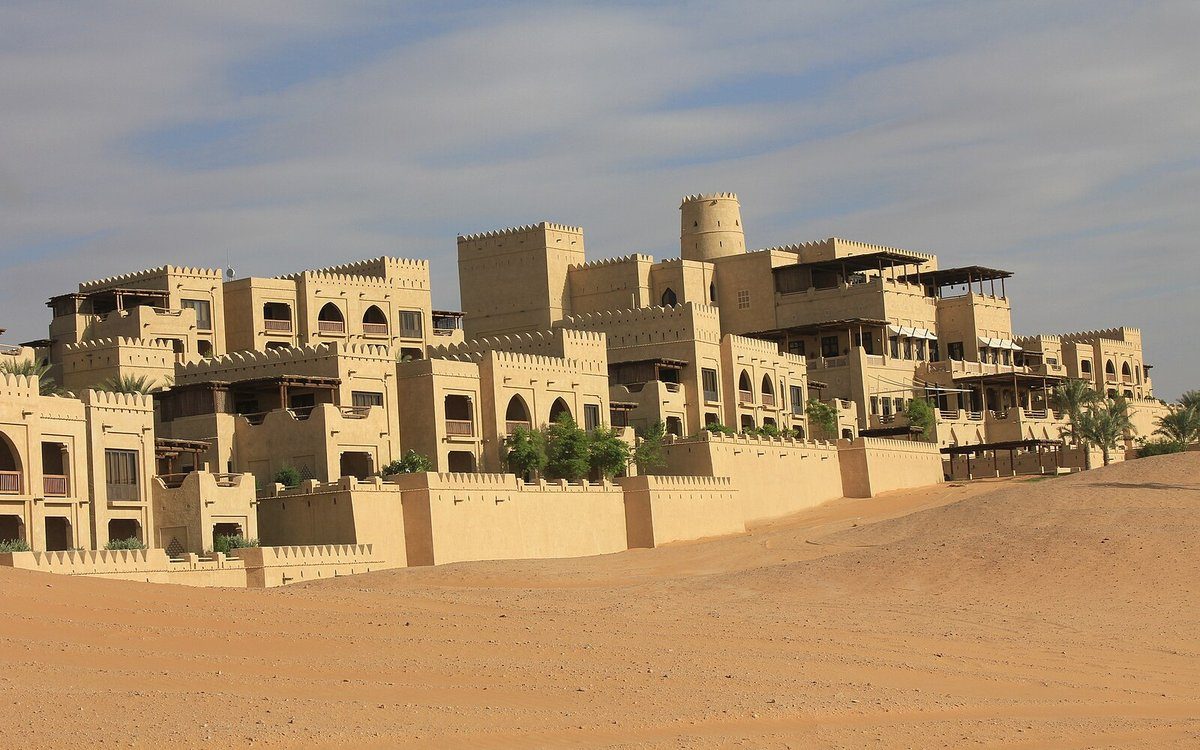Las almenas y terrazas color arena de Qasr Al Sarab, que se alzan entre las dunas del desierto de Liwa