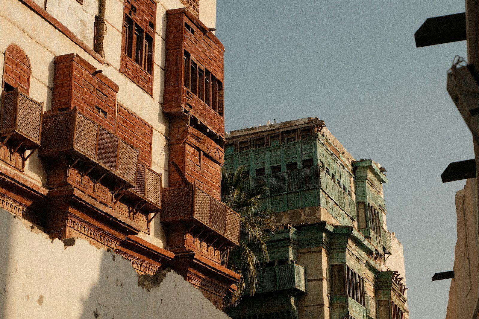 Balcones rawasheen de madera tallada, en teca envejecida y verde, en las casas torre de piedra coralina de Al-Balad, el Yeda histórico.