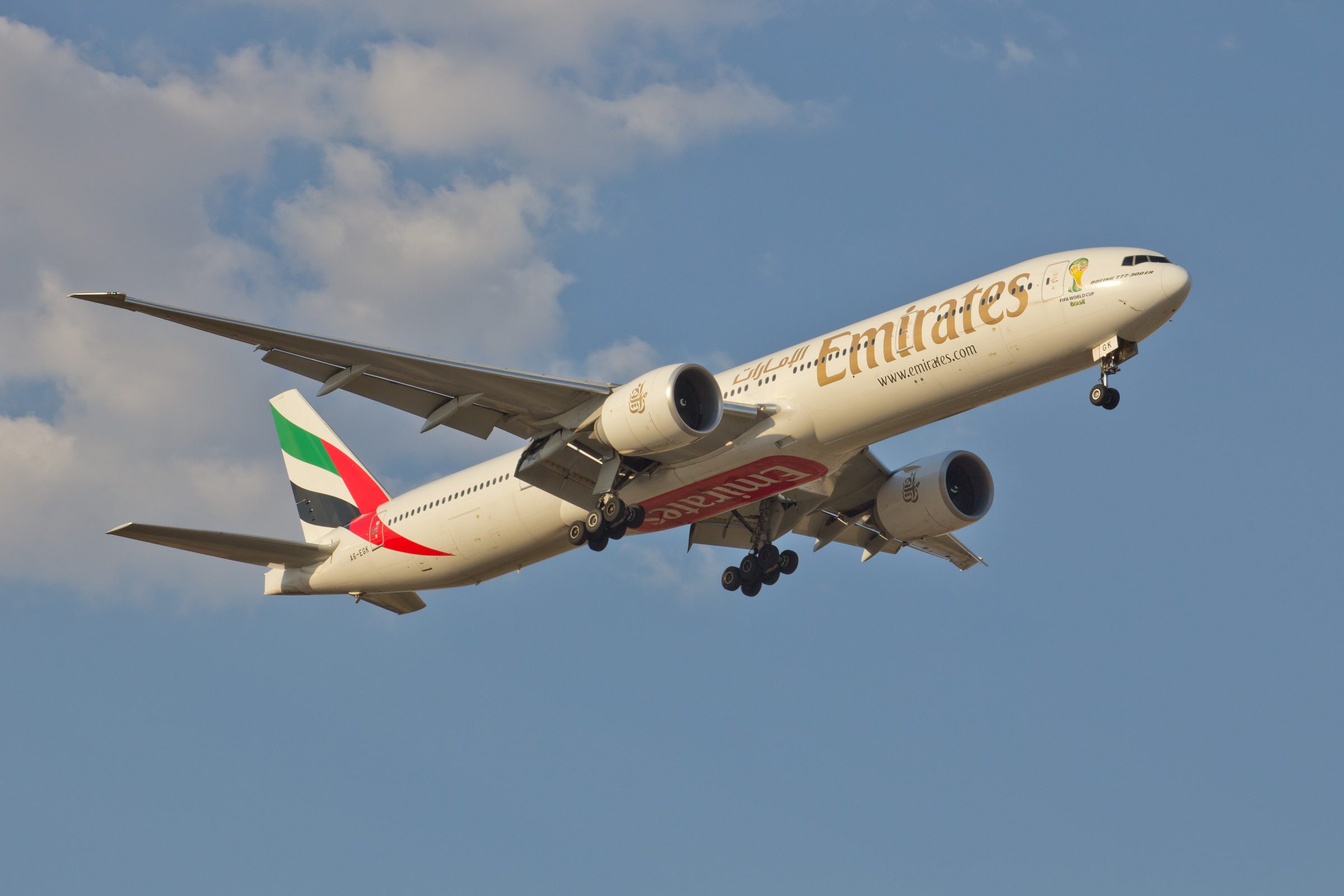 Un Boeing 777 de Emirates en ascenso hacia un cielo despejado