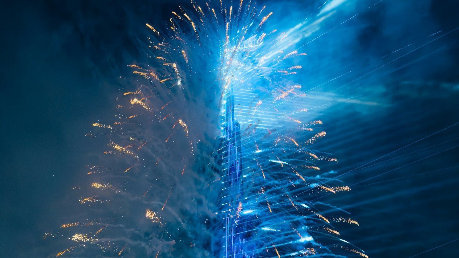 Fuegos artificiales en azul y dorado alrededor del Burj Khalifa en Nochevieja, Dubái