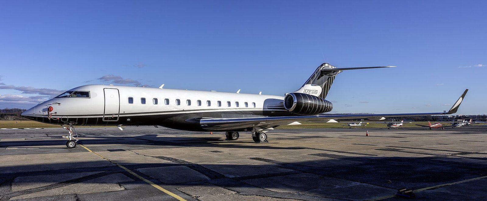 Un avión de negocios Bombardier Global 6000 estacionado en una plataforma de aviación privada bajo un cielo abierto.