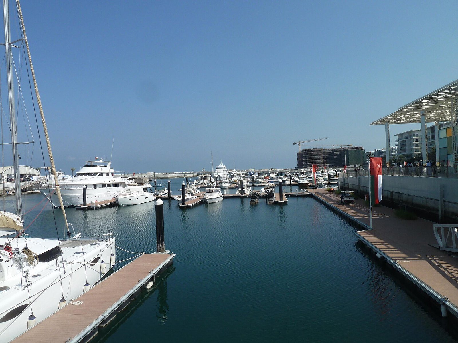 Yates amarrados en los pantalanes de Al Mouj Marina, el distrito residencial frente al mar de Mascate, bajo un cielo despejado.