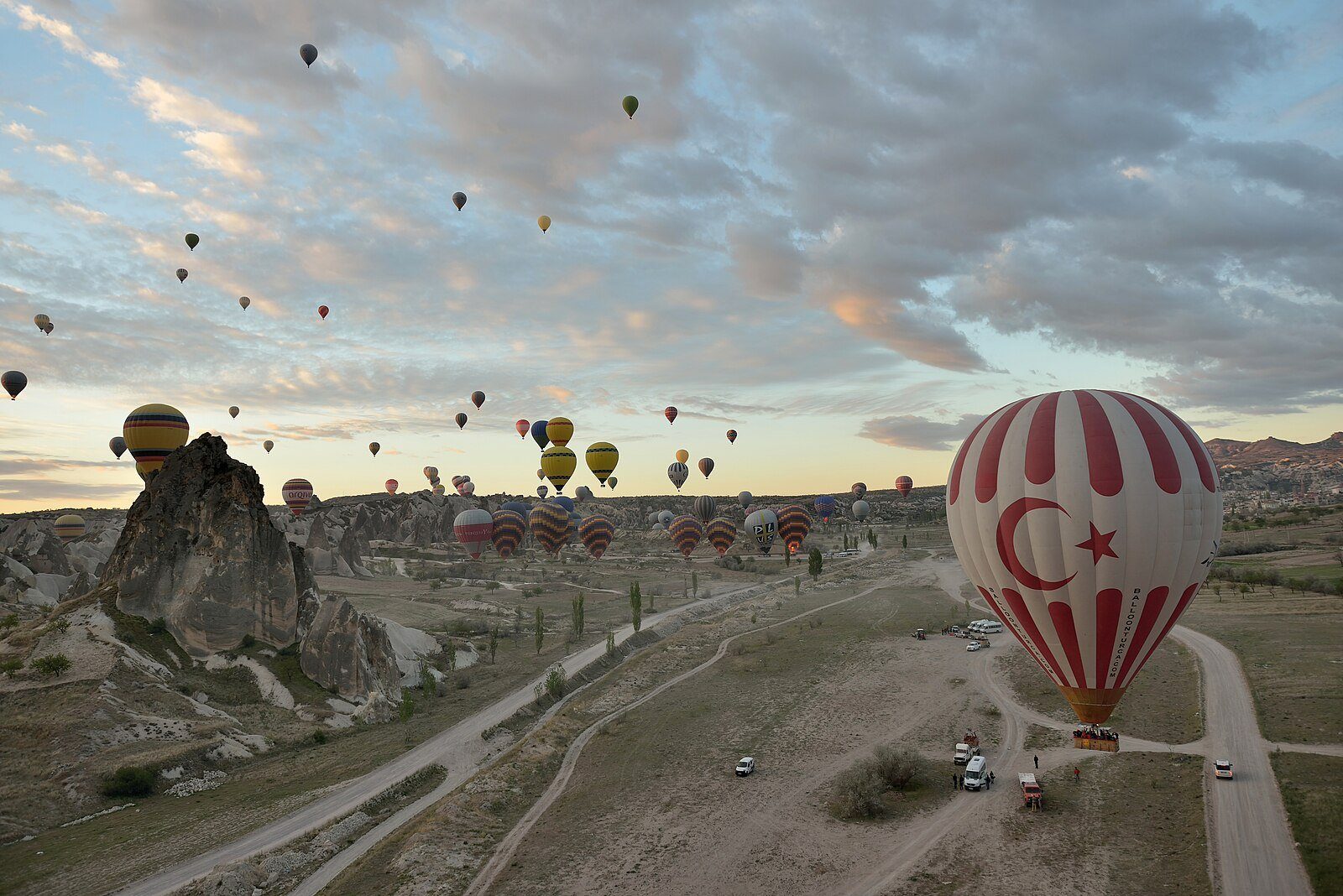 Decenas de globos aerostáticos elevándose al amanecer sobre las formaciones rocosas de Uchisar, en Capadocia.