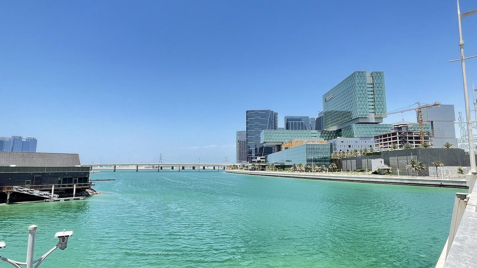 Aguas turquesas junto a la isla de Al Maryah en Abu Dabi, con las torres de cristal verde de Cleveland Clinic Abu Dhabi